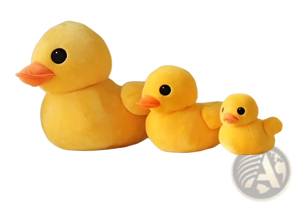 Three plush yellow rubber duck soft stuffed animals in varying sizes arranged on a white bench
