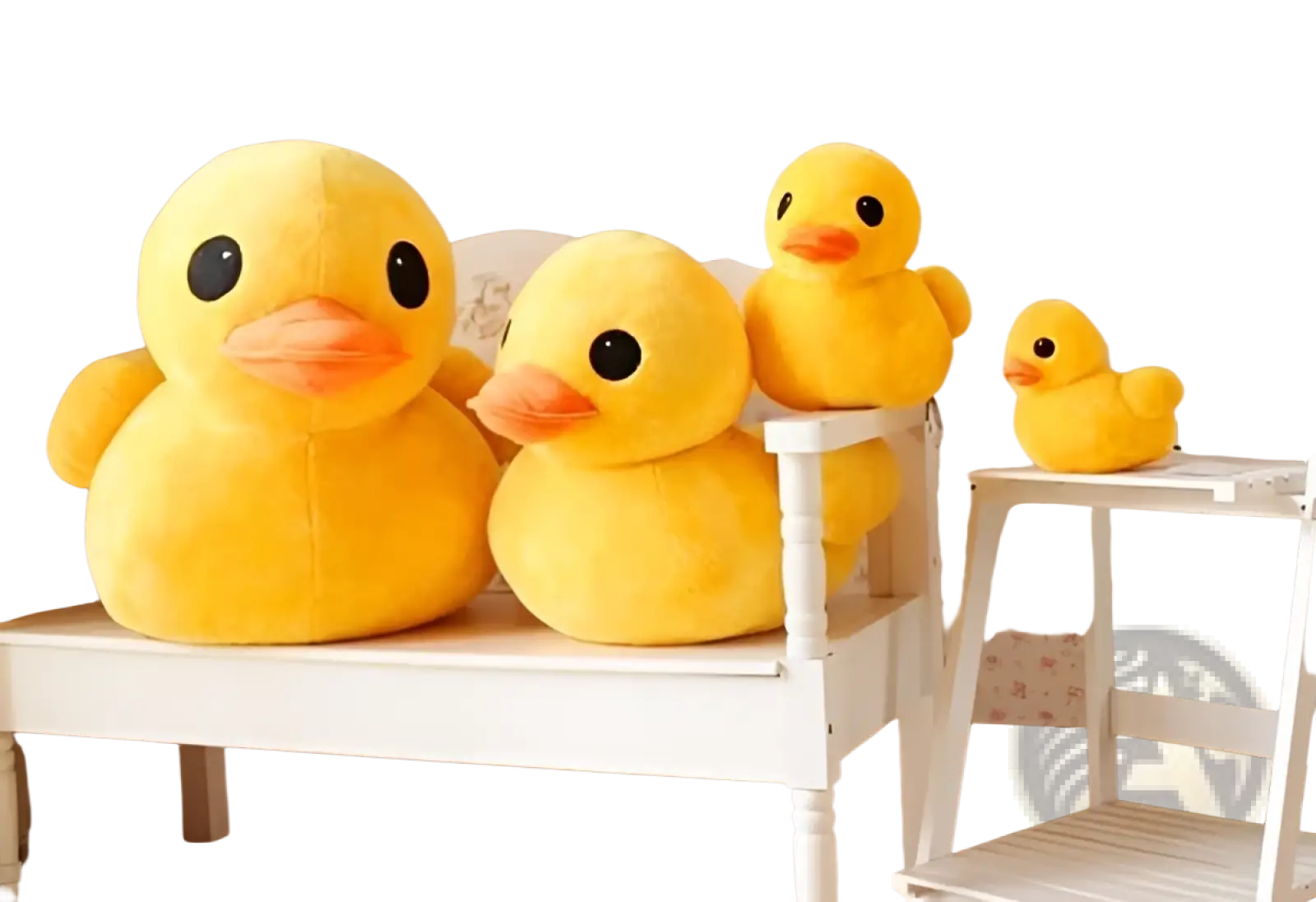 Plush yellow rubber duck toys soft stuffed animals in varying sizes arranged on a white bench