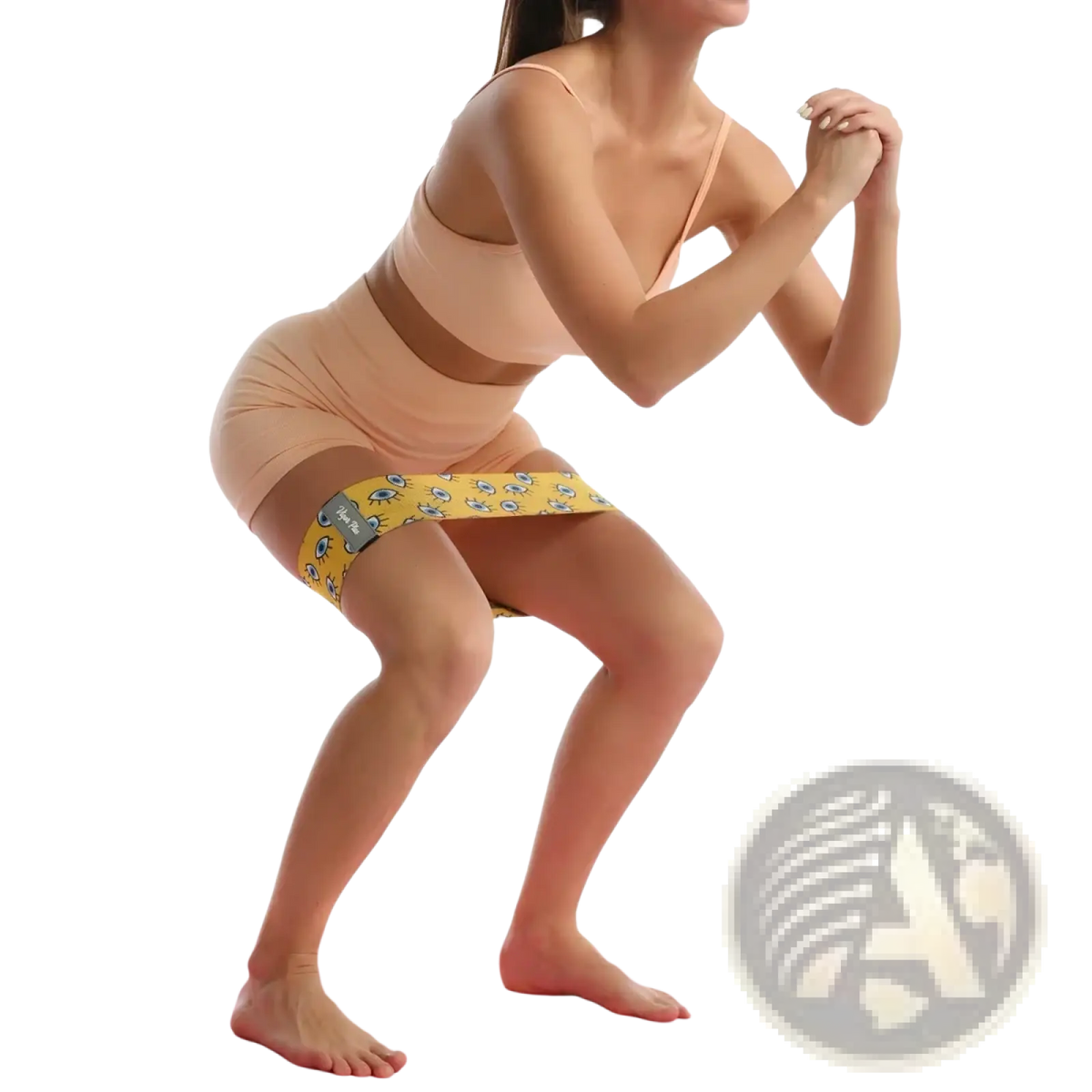 Yellow glute resistance band for women legs featuring a cartoon eye pattern worn around the thighs