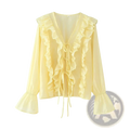 A delicate pale yellow long sleeve blouse with lace-up v-neck ruffled neckline and cuffs featuring front tie detail