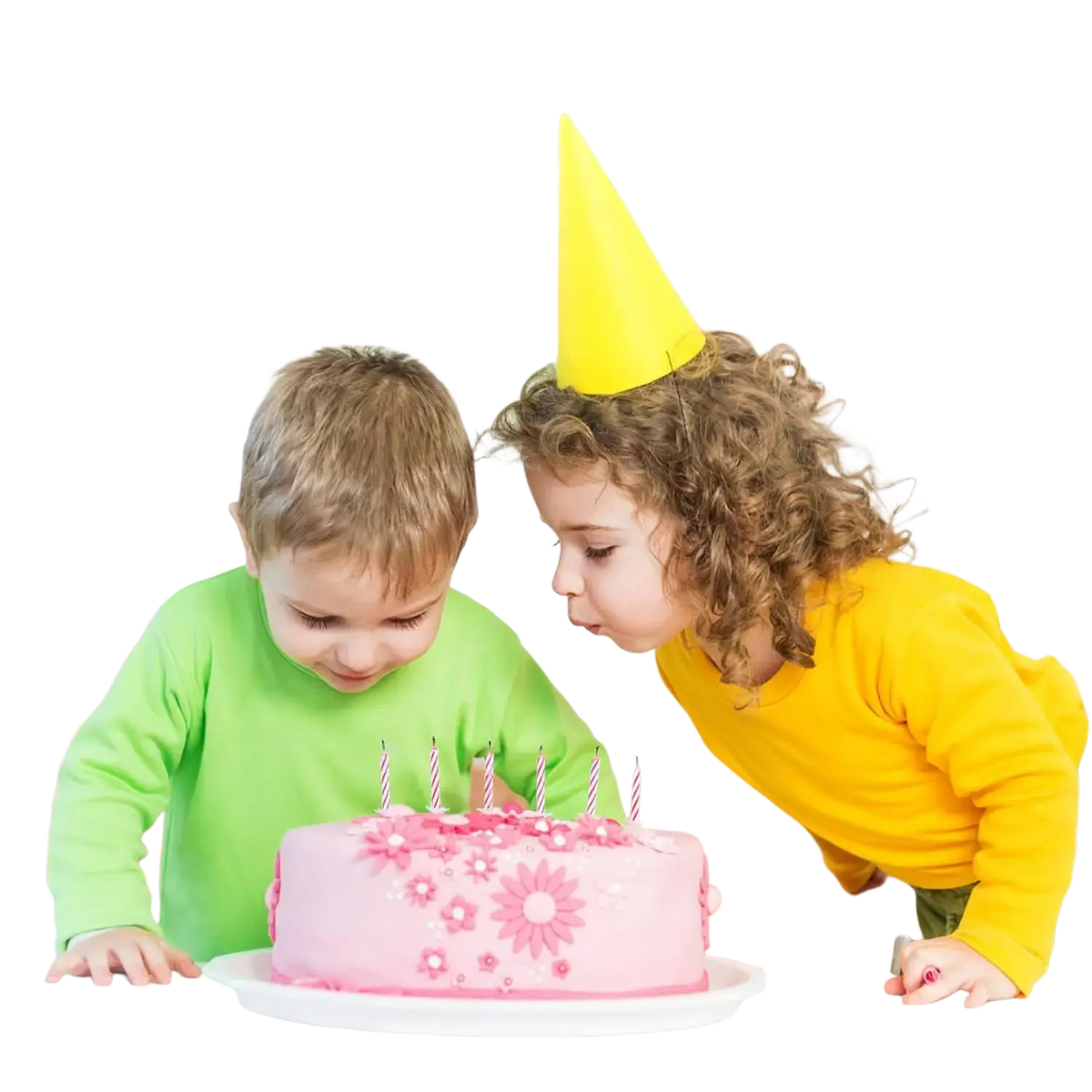 Pink birthday cake with pink floral decorations and white candles complemented by yellow party decorations paper fans and pom poms