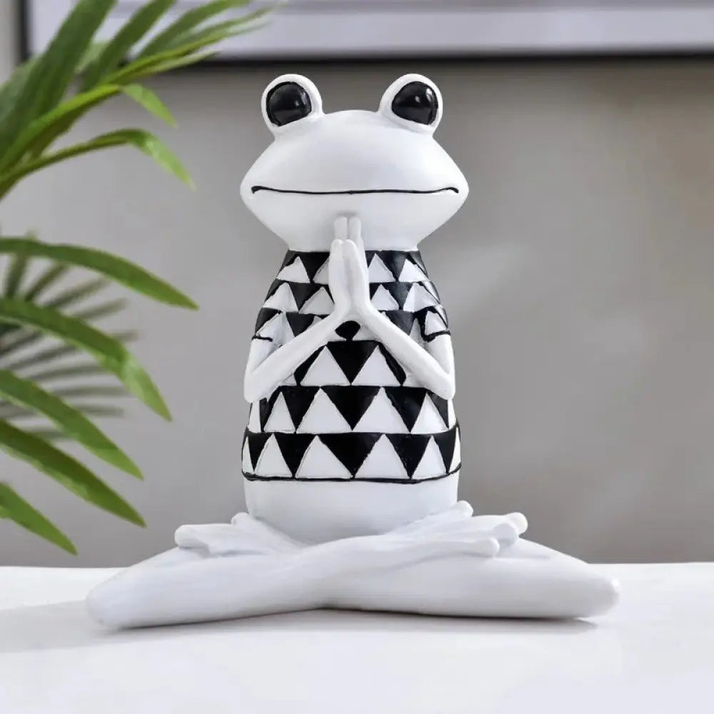 White ceramic yoga frog figurine with black triangular pattern and glossy black eyes in meditative pose