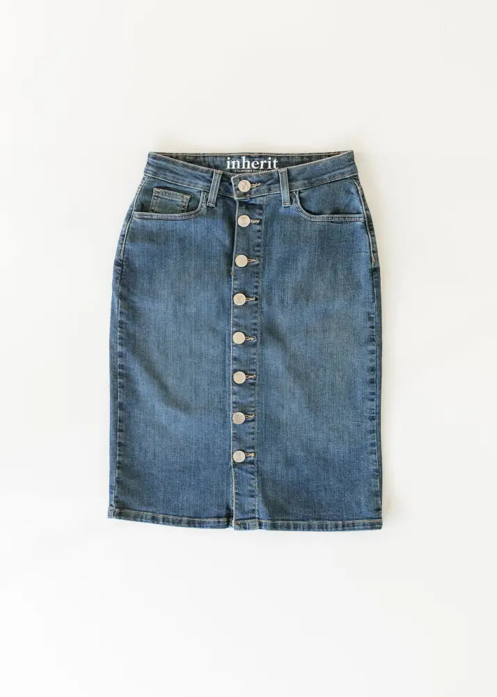 A mid-rise medium blue wash denim midi skirt with front button closure and classic patch pockets by Zana