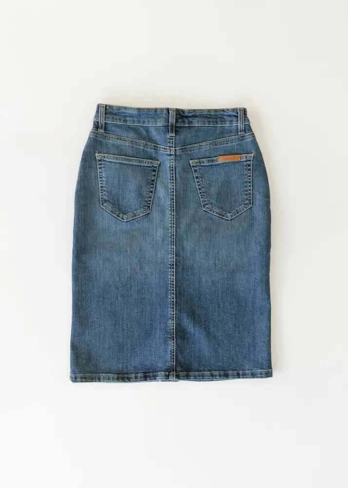 A mid-rise medium blue wash denim midi skirt with classic stitching and two back pockets shown from the back side