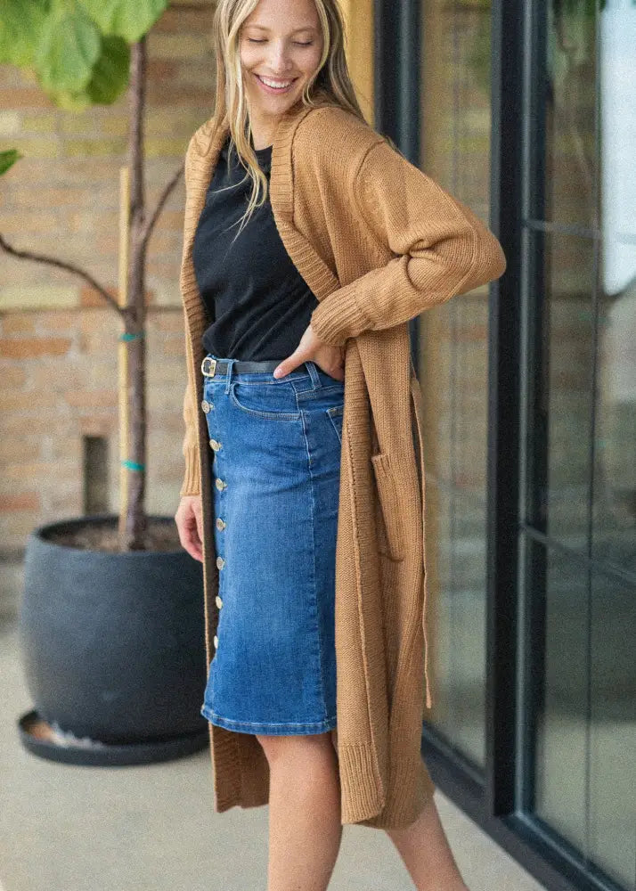 Tan knitted cardigan with relaxed silhouette and ribbed cuffs paired with zana front button denim midi skirt with kick pleat