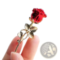 Zircon rose brooch with a translucent crystal red bloom and gold-toned stem and leaves pin accessory