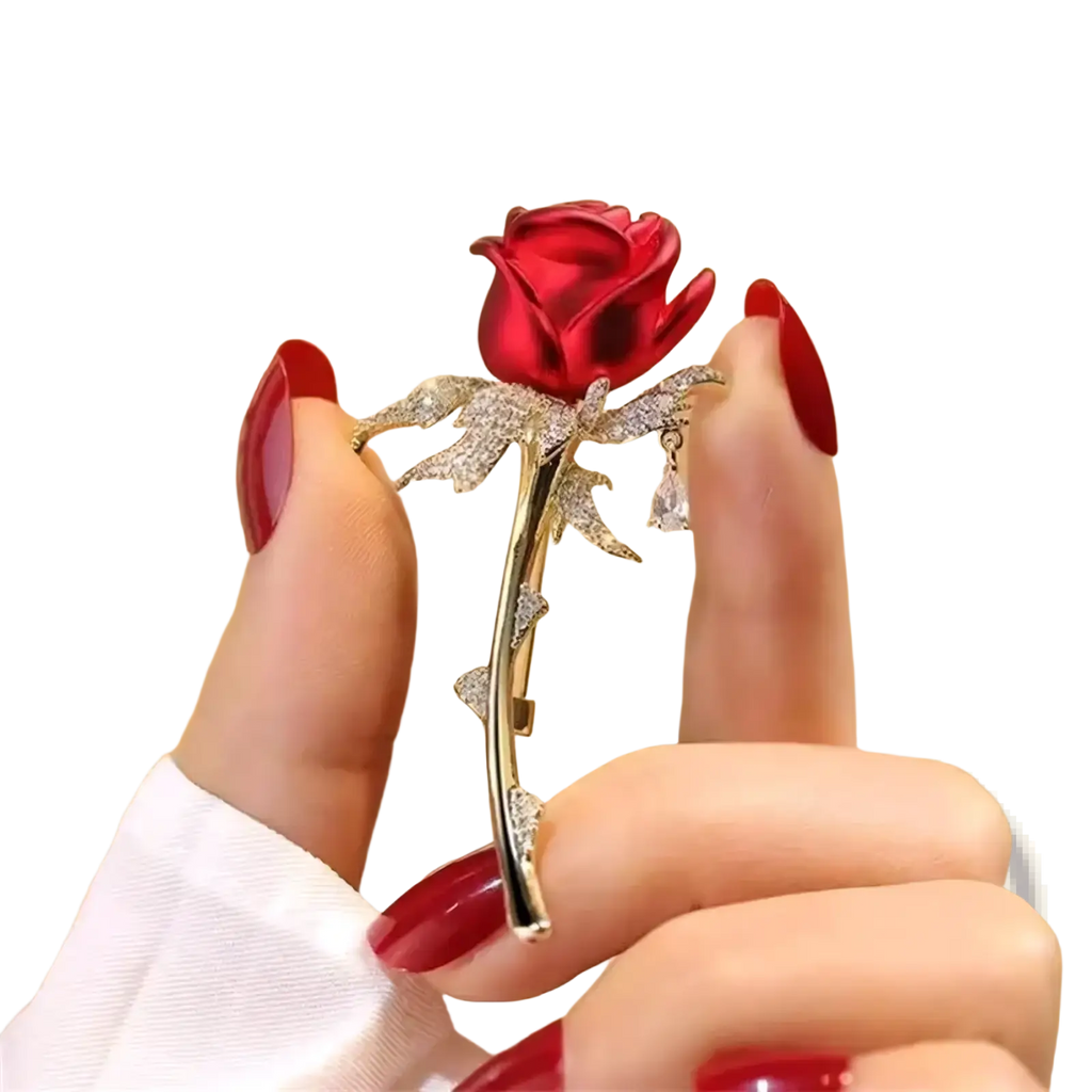 A sparkling red zircon rose brooch with gold-toned stem and clear crystal-adorned leaves